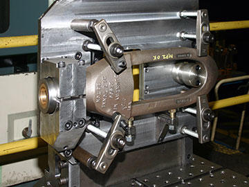 According to Tino Velasco, the machining strategy for this rod-hook bail casting – mounted on a Niigata pallet, ready for machining – is clearance. The opening in the plate provides access to machine from the back side.
